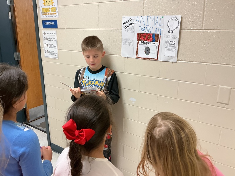 Student explaining his invention to peers.