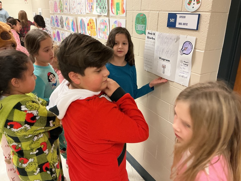 Student explaining his invention to peers.