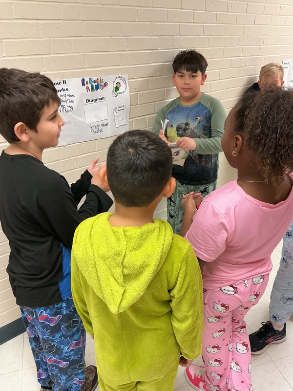 Student explaining his invention to peers.