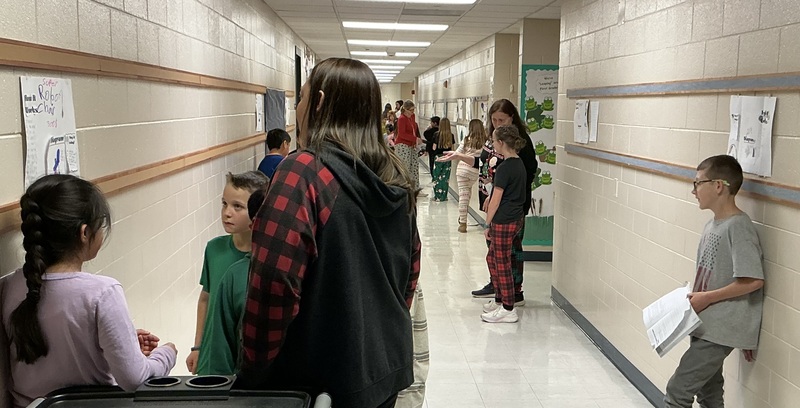 Student explaining their invention to peers.