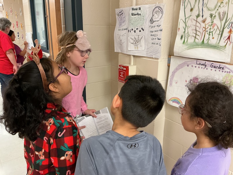 Student explaining their invention to peers.