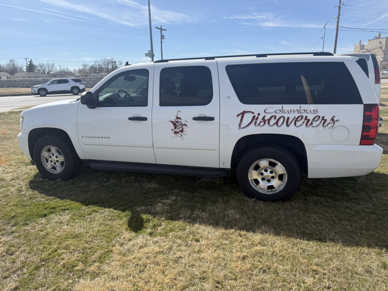 White suburban with old discoverer logos on the side