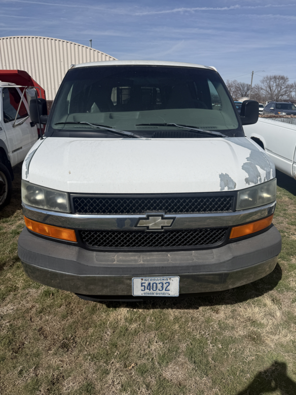 front view of white van with lift showing missing paint