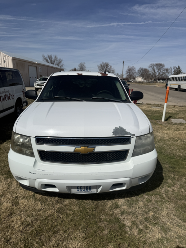 front view of white suburban with paint missing