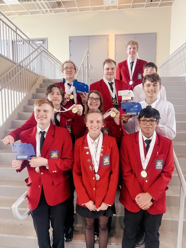 The CHS SkillsUSA state medalist pose on stairs with their respective awards.