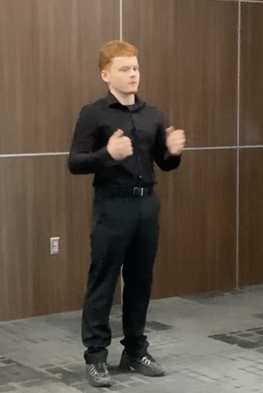 male student dressed in all black performing poetry