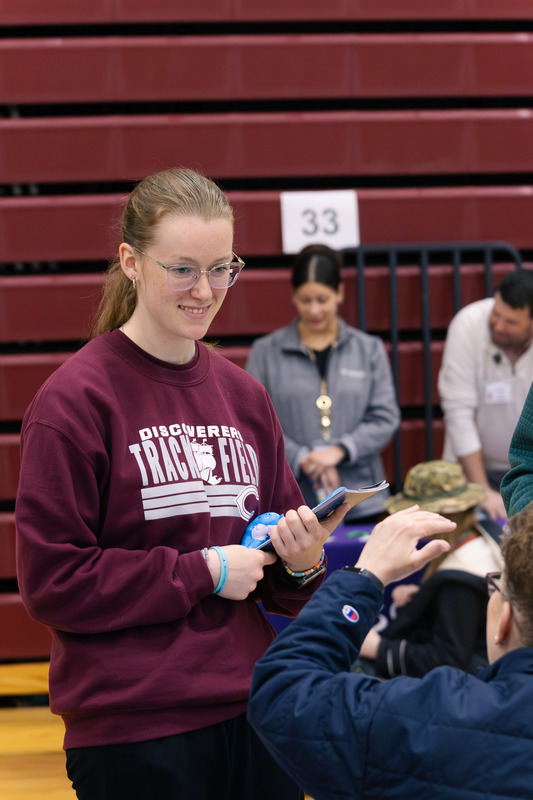A CHS student smiles as a college representative gestures.