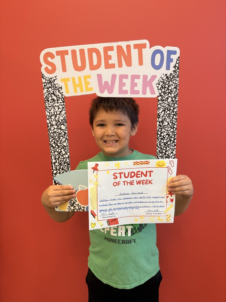student of the week smiling and holding up certificate