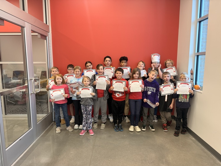 students stand holding their certificates making silly faces