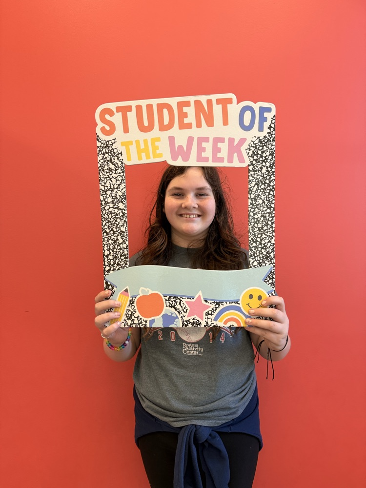 student holding student of the week sign