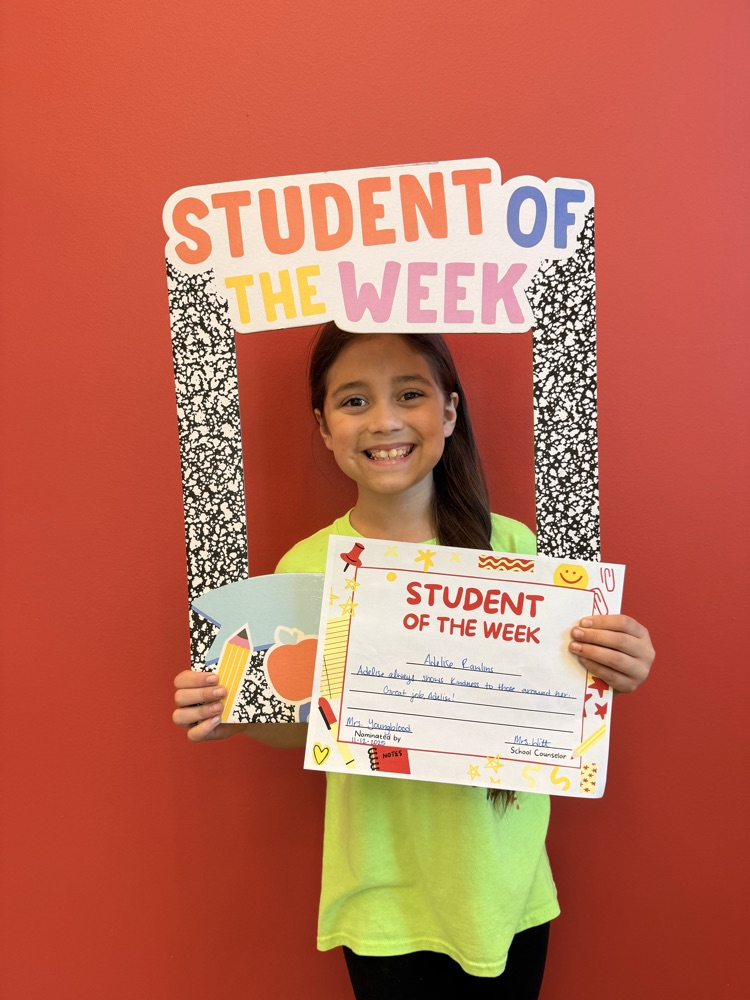 student holding student of the week sign
