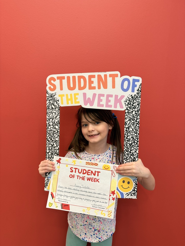 student of the week smiling and holding a sign