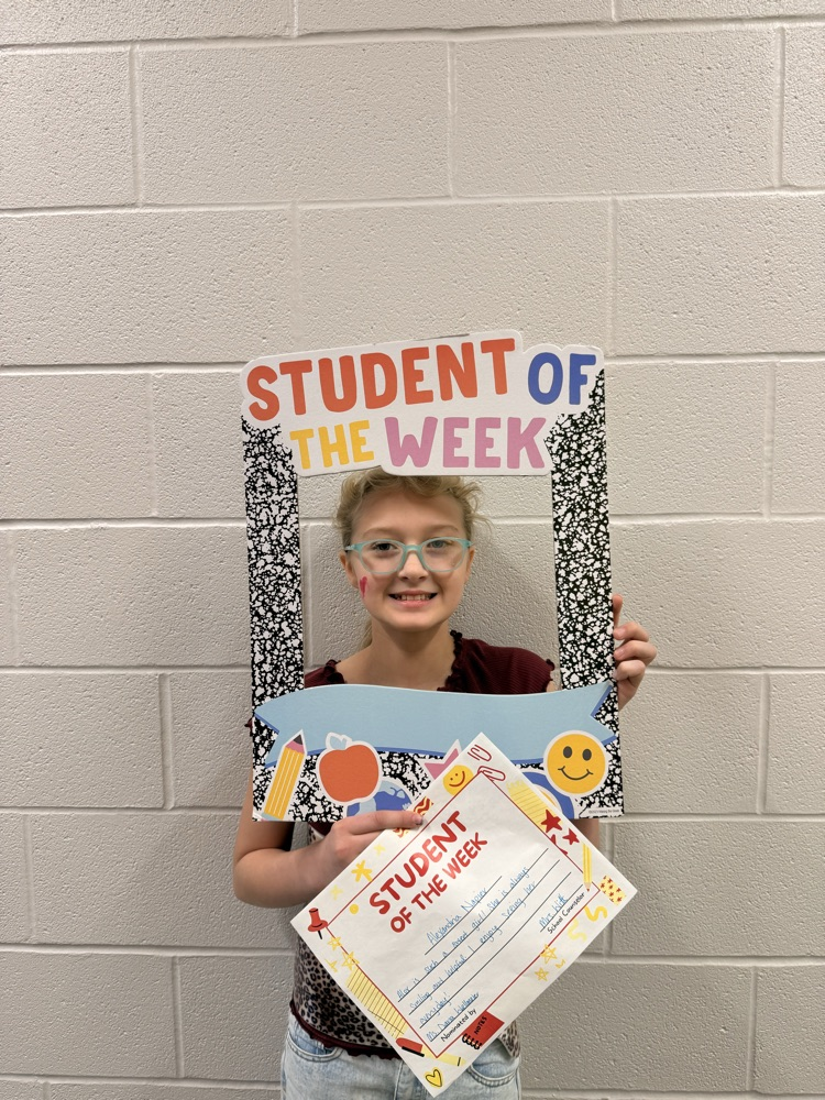 student smiling holding up sign and certificate 