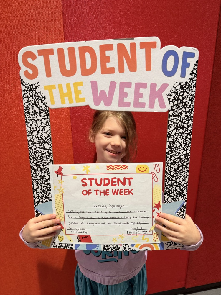 student of the week holding sign and certificate 