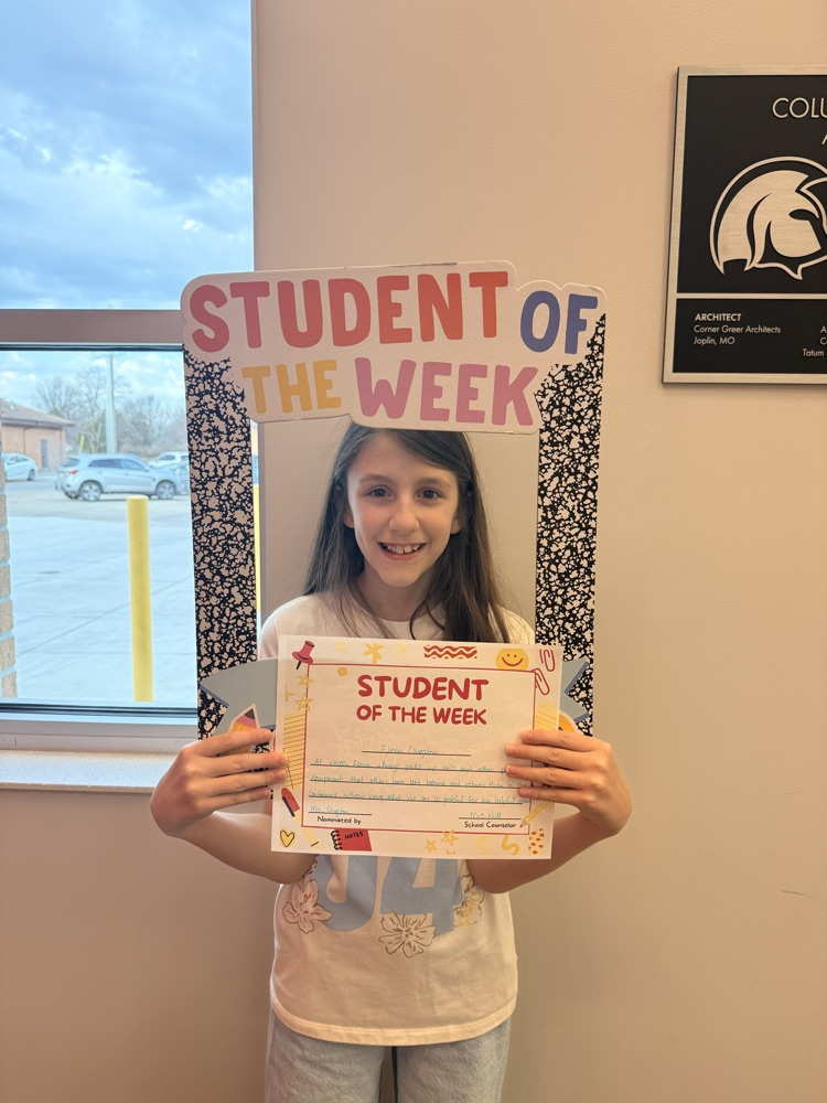 student holds up sign and certificate 