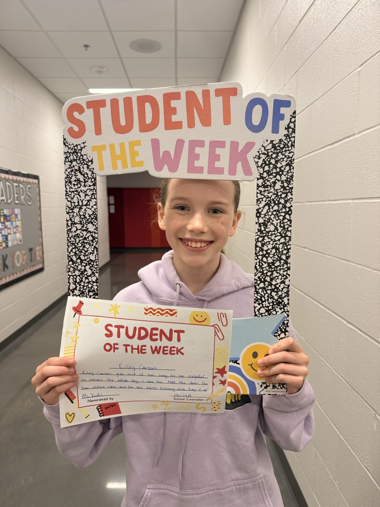 student smiles holding up sign