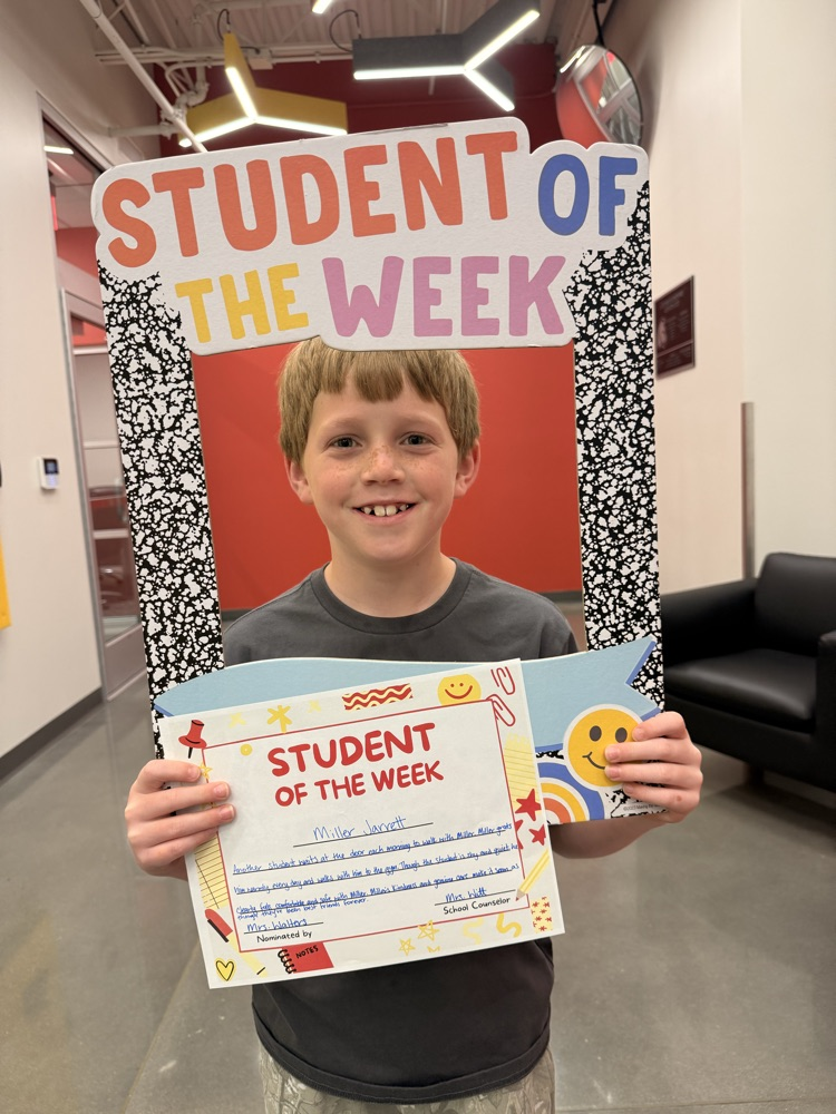student holds up sign smiling