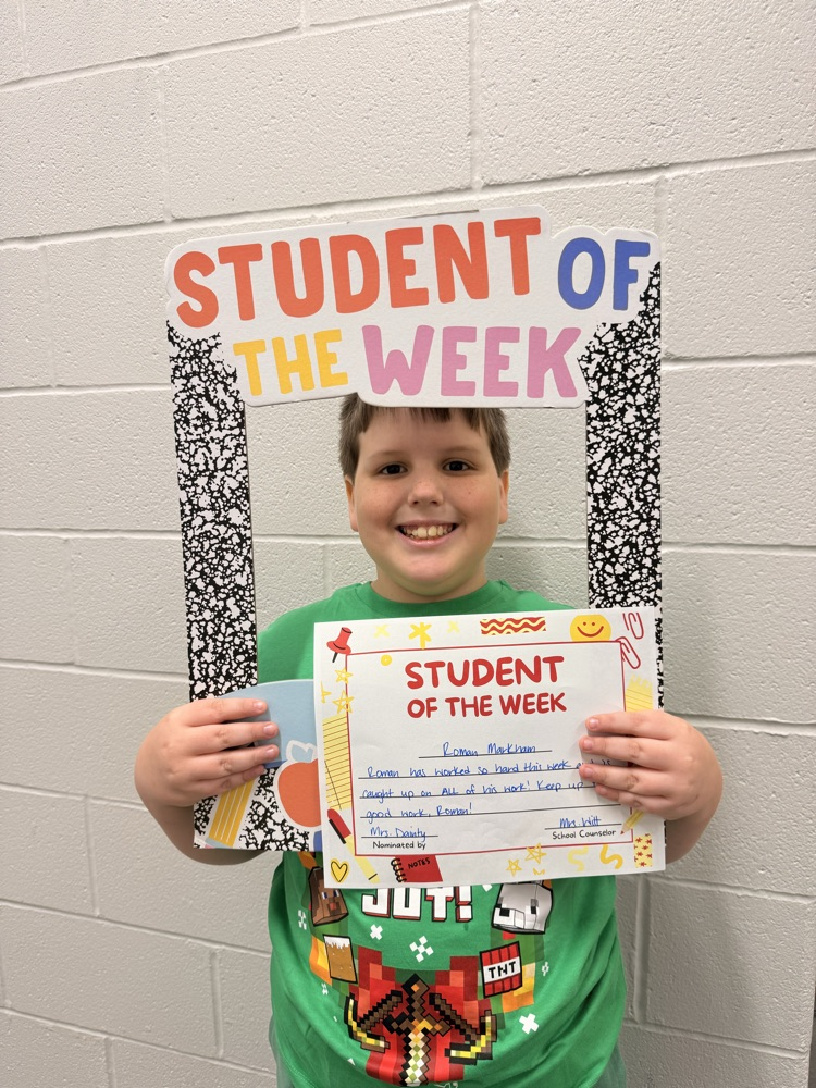 student smiles holding up sign