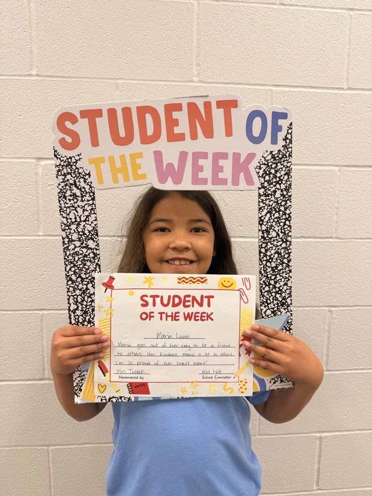 student smiles holding certificate and sign