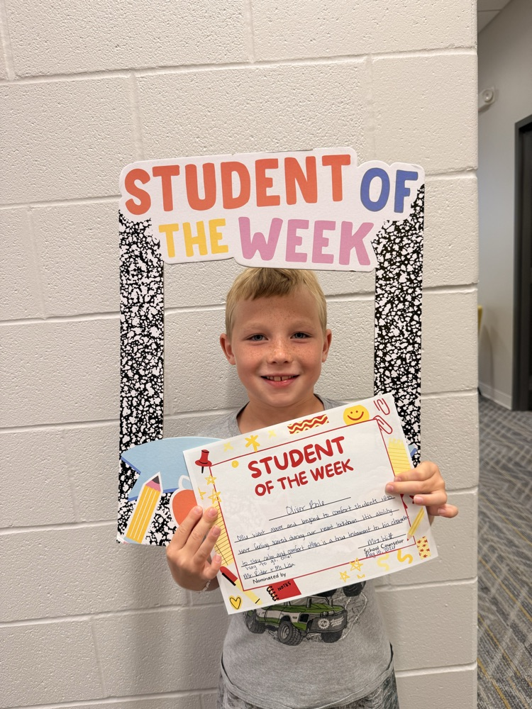 student smiles holding sign