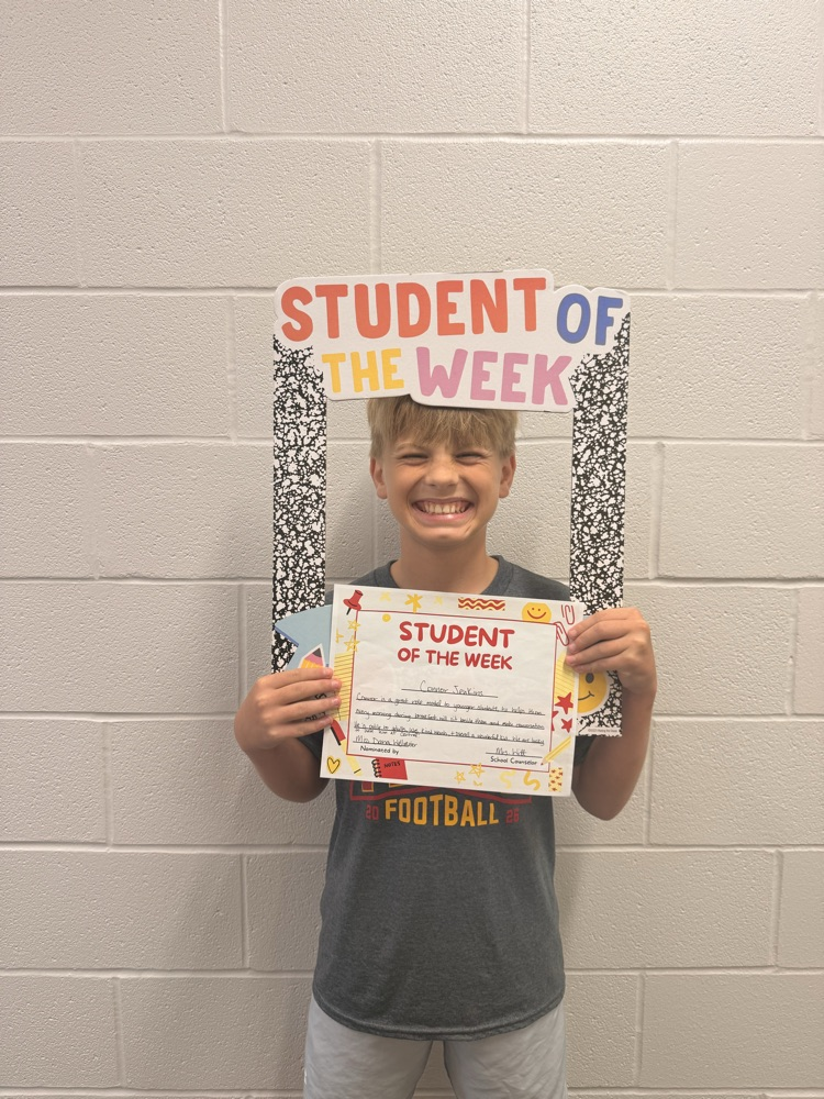 student smiling holding up sign