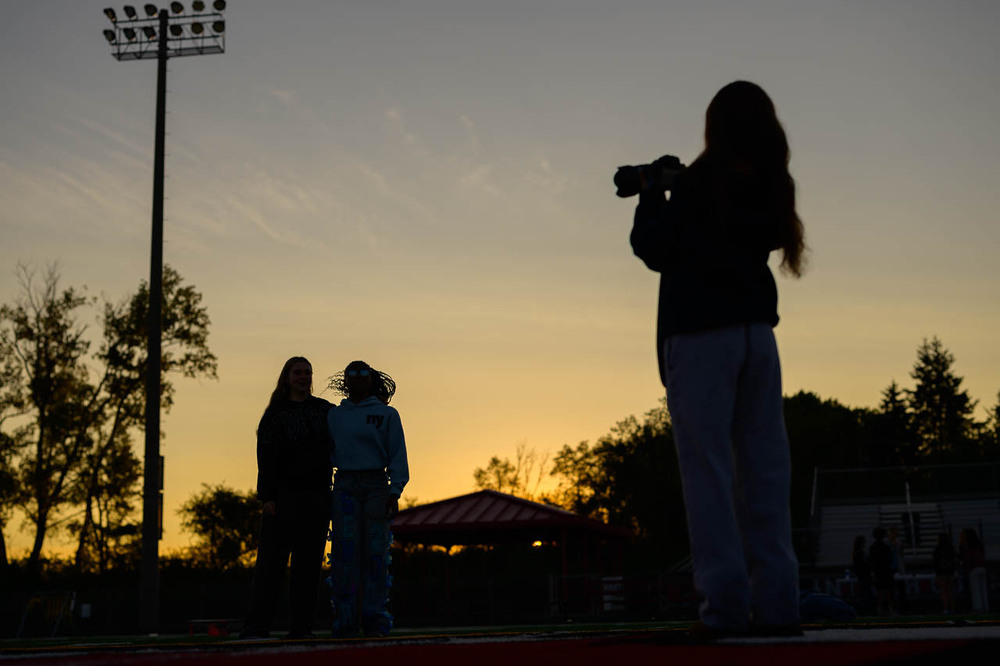 Students pose for a photo at senior sunrise. Sillhouette.