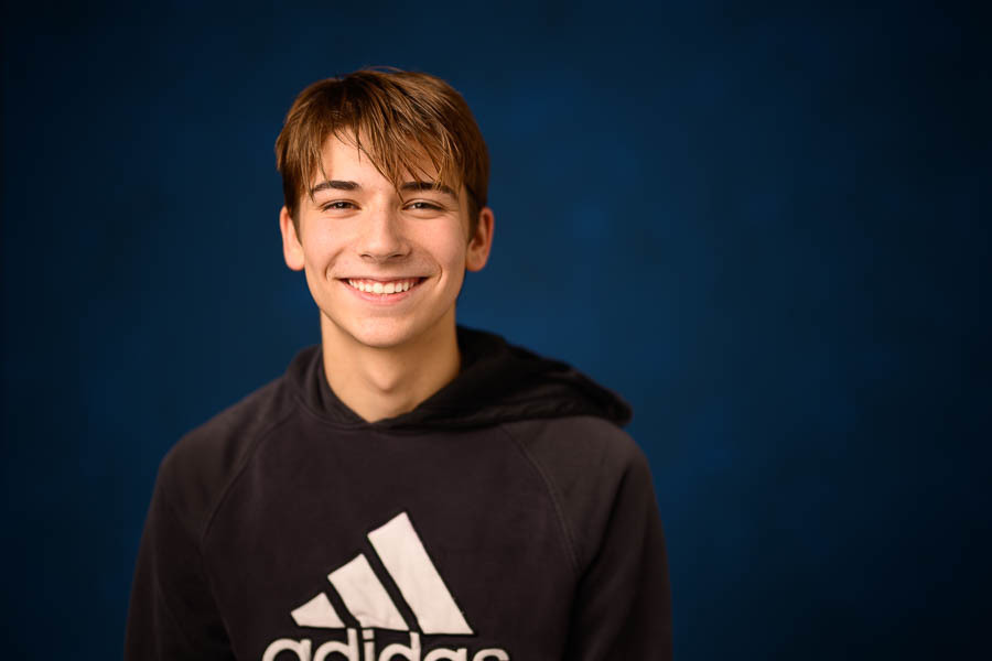 heashot portrait of Zolan Schieler against blue backdrop