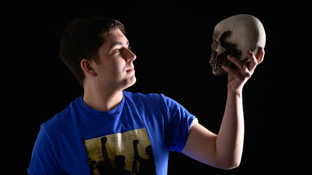 John Stahl with dramatic light, holding a skull