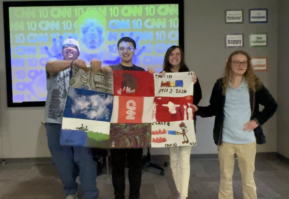 Picture of our Life Skills Academy kids holding up a CNN10 Banner That They Handmade