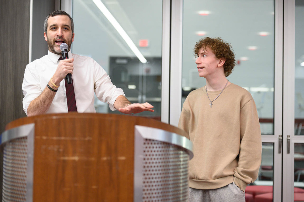 Student and teacher at podium in cafeteria