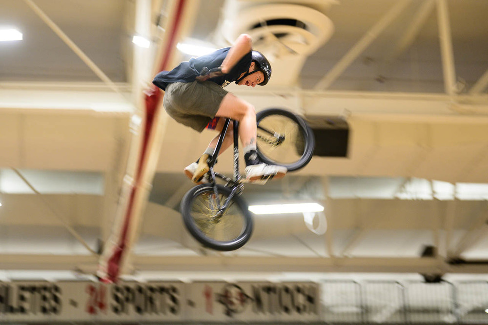 BMX biker flies through the air in the north gym.