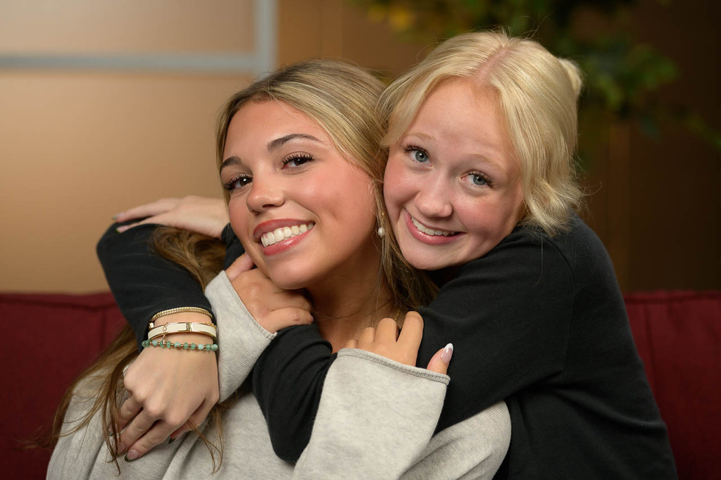 Two students hug. Head and shoulders pic.