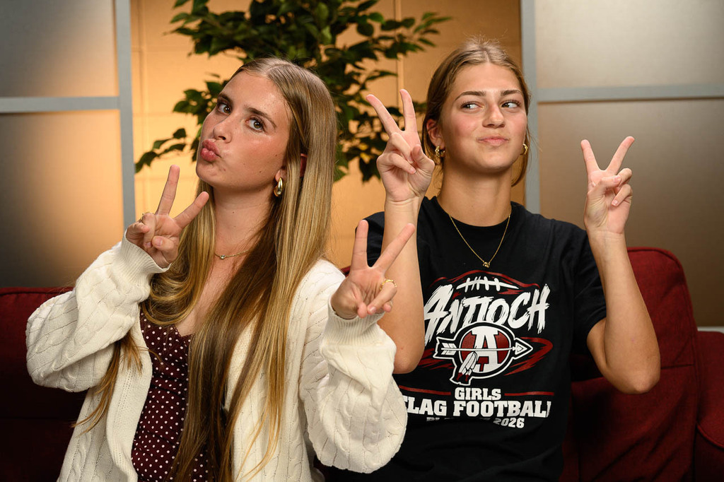 Two girls give peace signs  on Sequoit Speakers morning show set.