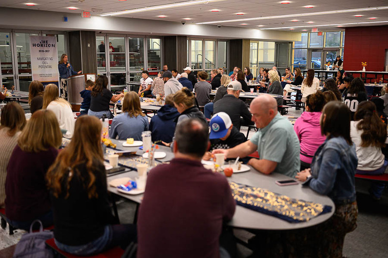 A crowded school cafeteria with attendees seated at tables during the You Make a Difference Breakfast.