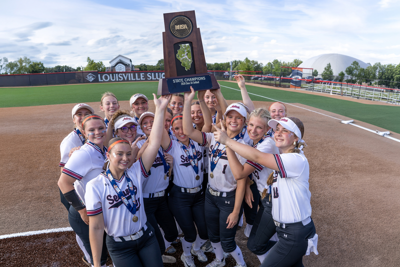 Group of Women Softball Players holding up a trophy