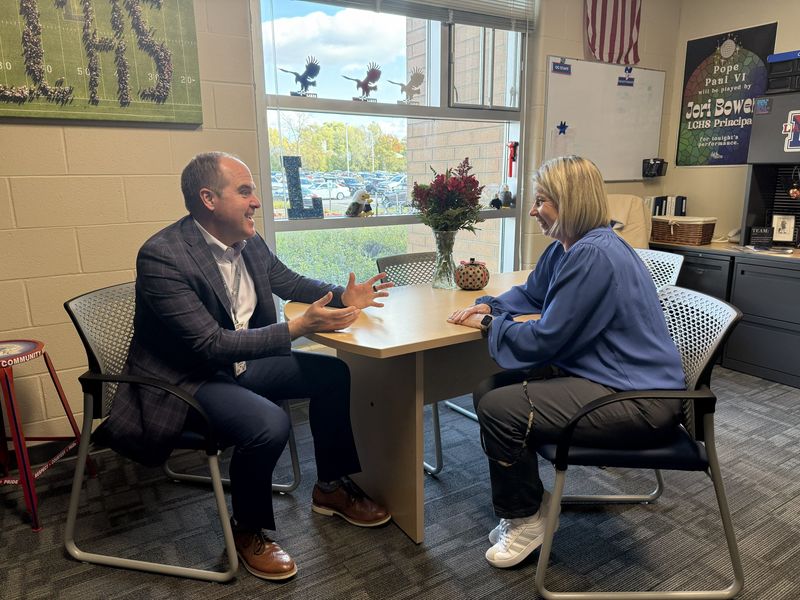 A man and a woman sitting across from each other at a table talking
