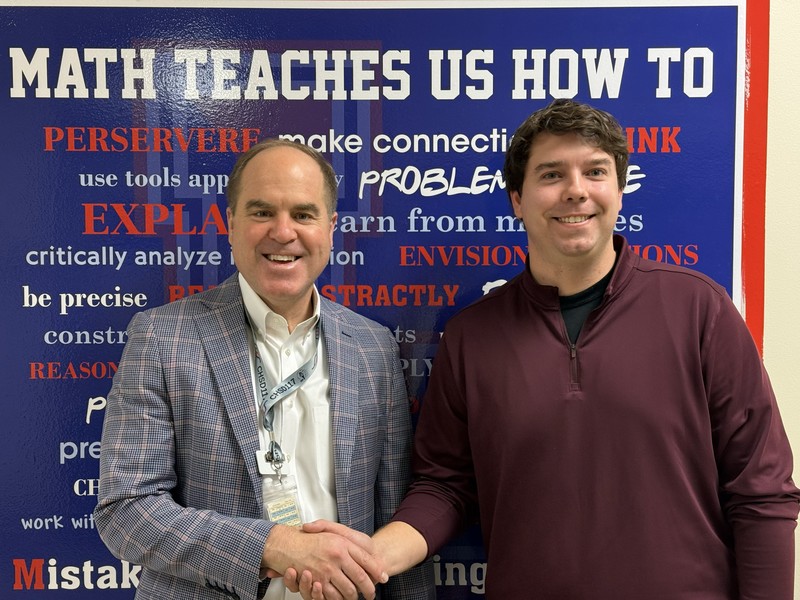 Two men standing next to each other while shaking hands