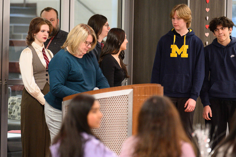 students surround teacher at podium