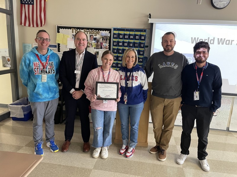 Group of 6 people awarding a certificate to a blonde woman