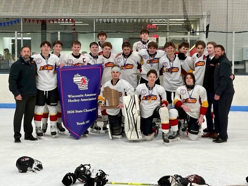 Teenage male hickey tem holding championship banner