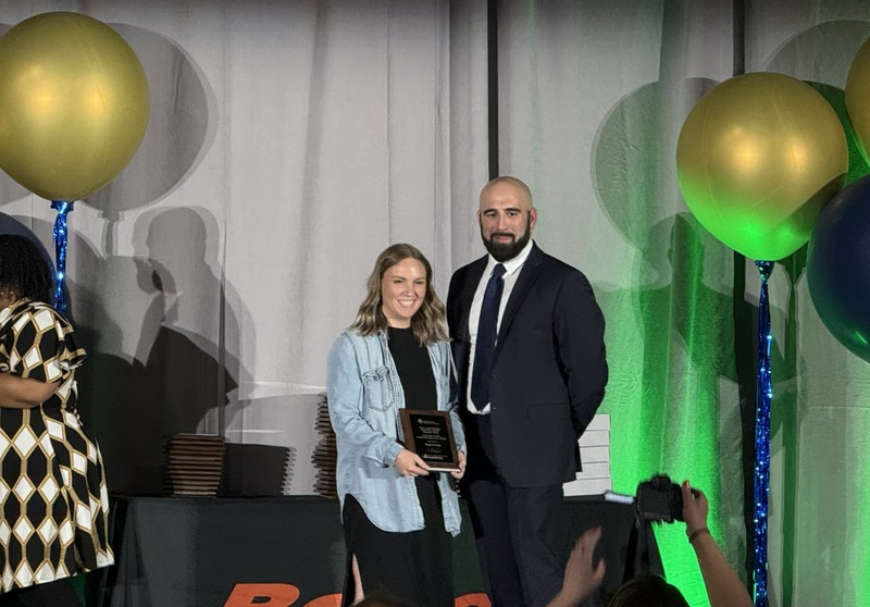 Man and a women dressed nicely. Woman receiving an award.