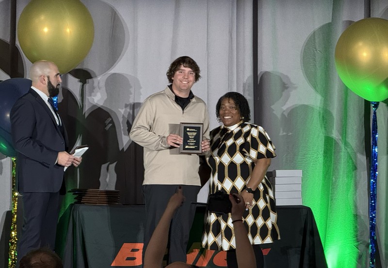 Man and a women dressed nicely. Woman receiving an award.