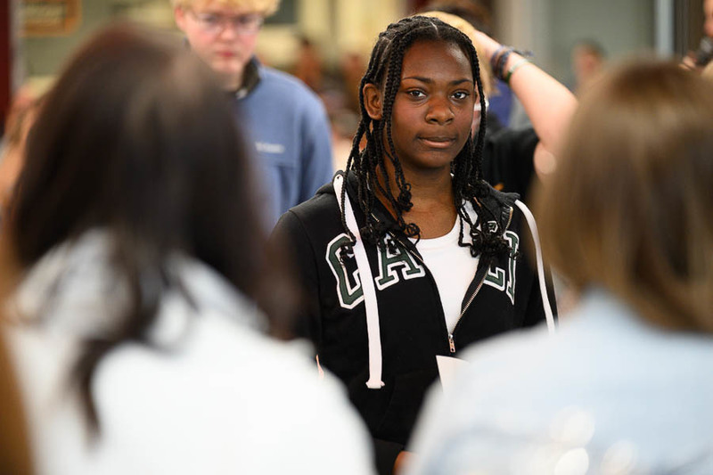 Student in a crowd makes eye contact with camera