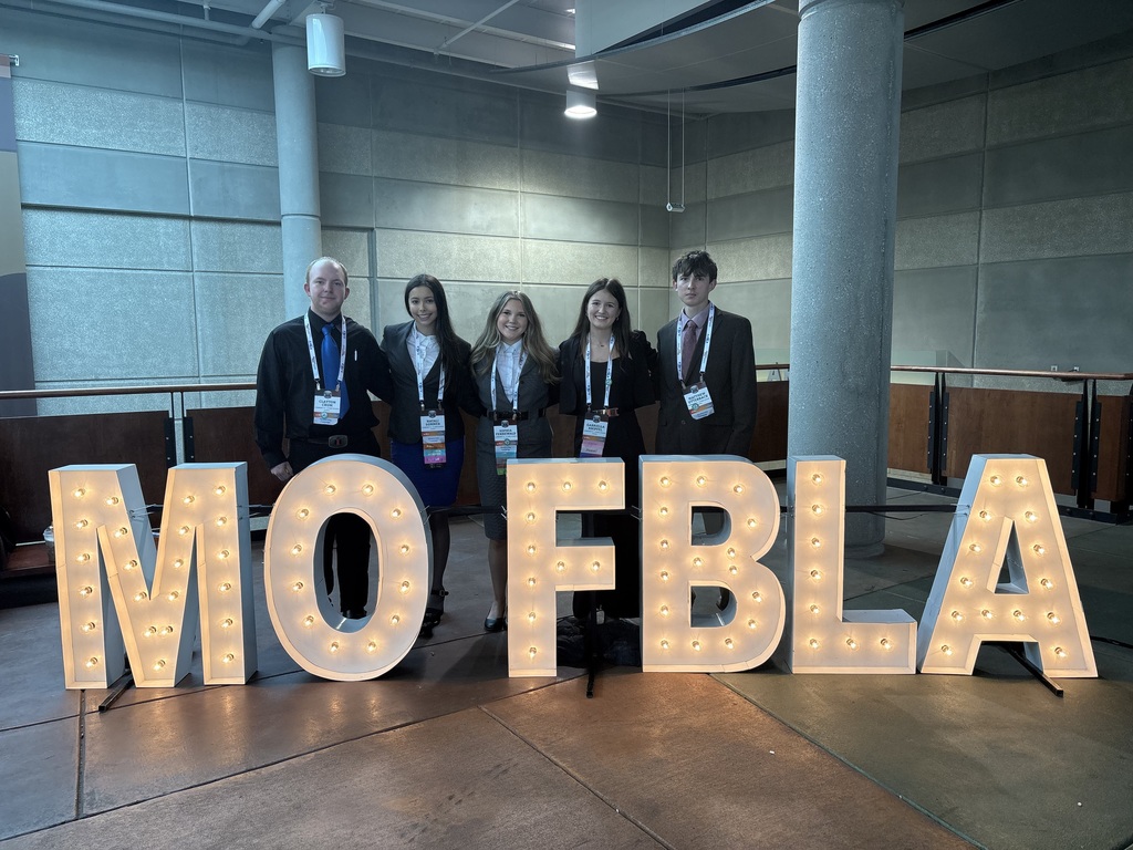 Our FBLA just returned from Springfield, and we are so proud to announce that our parliamentary procedure team — Sophia Fennewald, Gabriella Knipfel, Natali Sommer, Matthew Utterback, and Clayton Crum — placed 8th in the state!  Special shoutouts: Natali competed in Introduction to Public Speaking in the preliminary round on Sunday and advanced to the finals on Monday. Final results place her in the top 15 in the state! Matthew competed in Personal Finance. Sophie competed in Introduction to Parliamentary Procedure. We’re so proud of all five students for their hard work and dedication. Please join us in congratulating them! Clayton, Natali, Sophie, Gabby and Matthew pose behind  a lit sign that reads MO FBLA