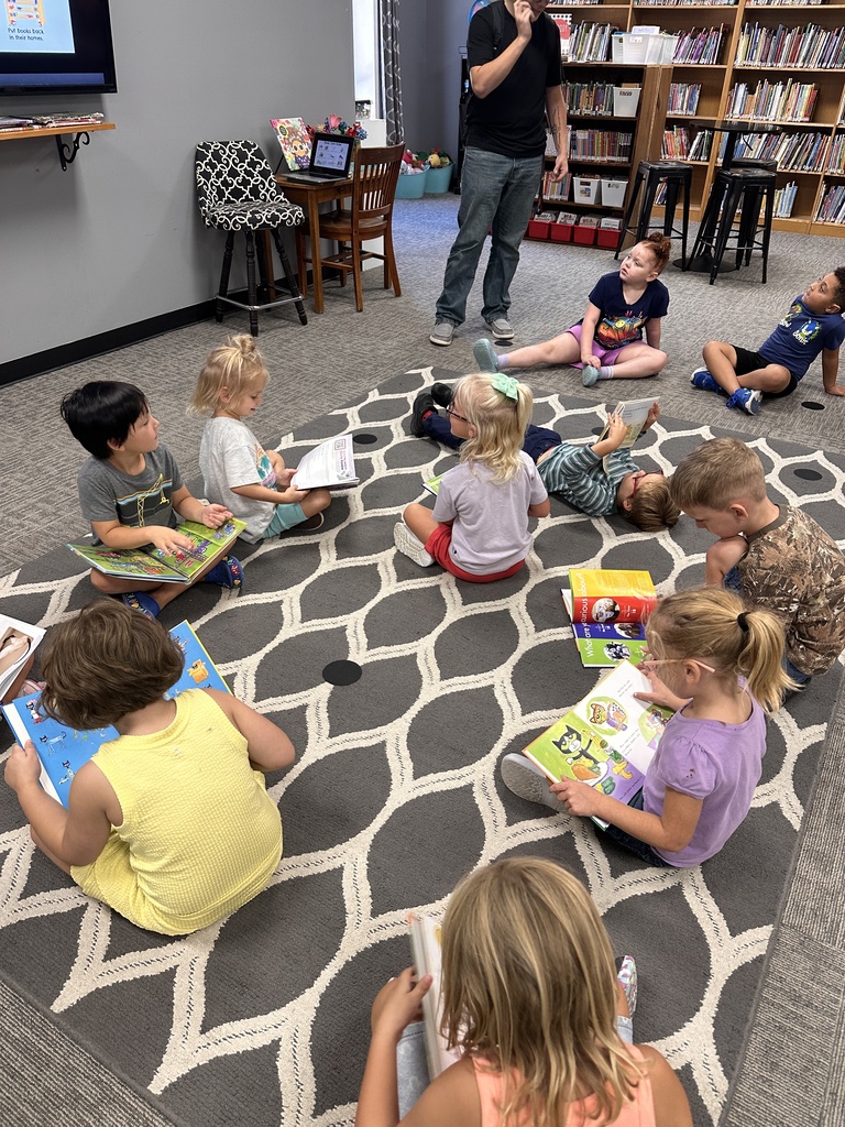 Students reading library books. Last week our kindergarteners experienced the joy of checking out their very first library books!