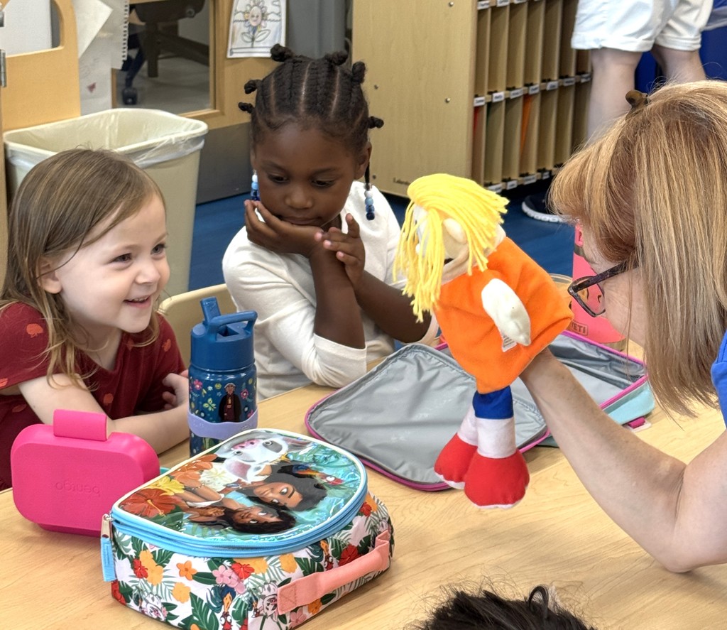 Teacher showing puppet to students