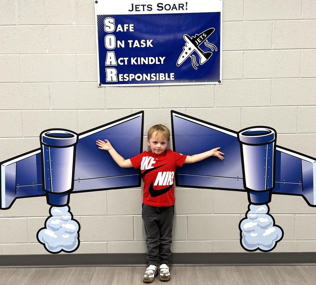 Boy standing against mural of jet