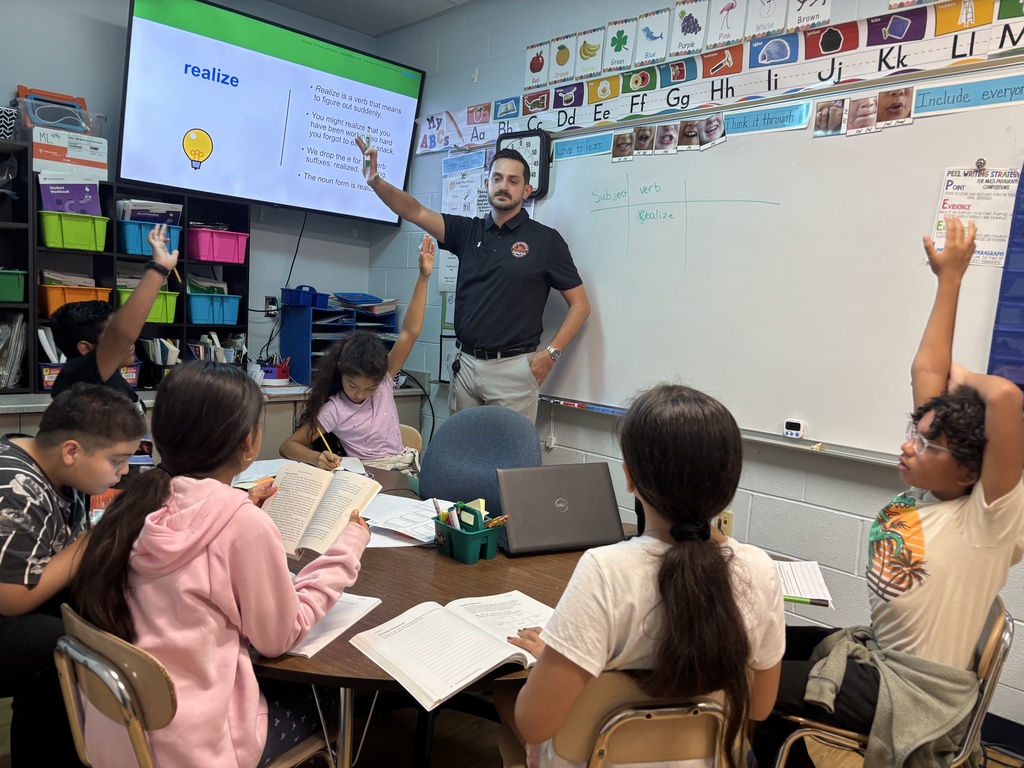 teacher with kids and hands raised