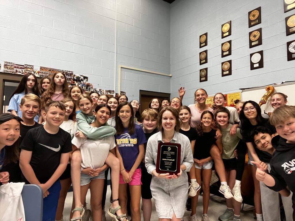 orchestra director surrounded by students