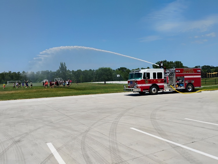 Fire truck spraying hose on students  
